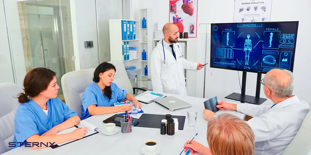 Medical staff in front of computer workstation discussing about cybersecurity threats in healthcare